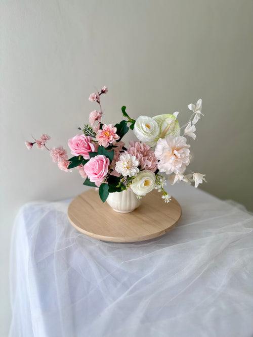 Floral arrangement on a ceramic vase with a white background